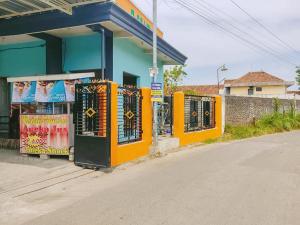 a gas station with an orange and blue building at RedDoorz Syariah near Lippo Plaza Sidoarjo in Sidoarjo