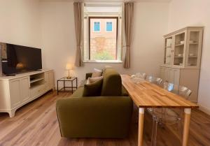 - un salon avec un canapé vert et une table en bois dans l'établissement Palazzo Pitagora, à Tarente