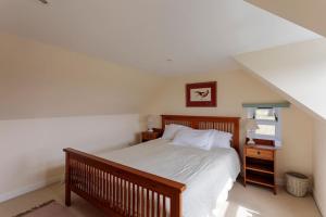 a bedroom with a bed and a desk and a window at Blackhill Farm Cottage in Perth