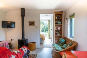 a living room with a wood stove and chairs at The Potting Shed in Woodstock