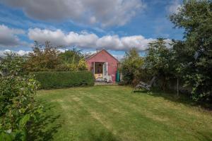 a red house with a bench in the yard at The Potting Shed in Woodstock