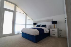 Schlafzimmer mit einem blauen und weißen Bett und Fenstern in der Unterkunft Northumberland Luxury Stays - The Gavel in West Chevington + 43 Fotos