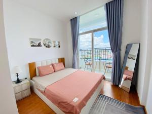 1 dormitorio con 1 cama y balcón en Alpha Homestay Marina Long Xuyên en Ấp Ðông An (1)