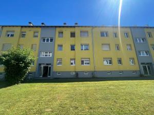 un bâtiment jaune avec une cour herbeuse devant lui dans l'établissement Wohnung zum Wohlfühlen!, à Feldbach
