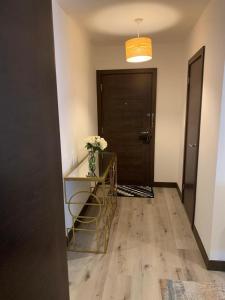 a hallway with a door and a table with flowers on it at Ackroyd House, Edinburgh Way in Harlow