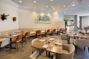 um restaurante com mesas e cadeiras num quarto em Winston-Salem Marriott em Winston-Salem