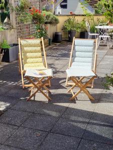 2 sillones sentados en una acera junto a una mesa en Poésie en partage, en Giromagny