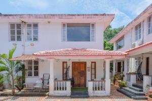 a white house with a red roof at Paradiso Villa -2BHK villa with Pool-Vagator By StayMonkey in Vagator