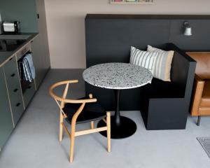ペンブルックシャーにあるSubterranean Studio with Panoramic Costal Viewsのテーブルと椅子付きの小さな部屋