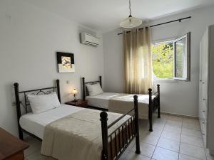 a bedroom with two beds and a window at Villa Kephalos in Spartia +28 photos