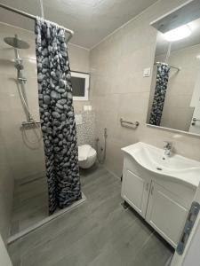 a bathroom with a shower curtain and a sink at Apartment Panorama Mostar in Mostar