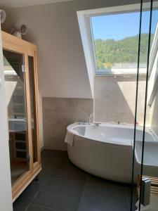 a bath tub in a bathroom with a window at eco boutique hotel AMS Beagle in Bled