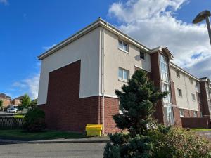 a brick building with a large door on the side of it at Flat Five, 212 Eaglesham Road, East Kilbride, Glasgow in East Kilbride