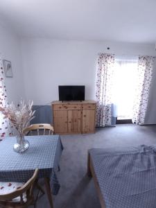 a living room with a table and a television at Pension Bernhard in Landl