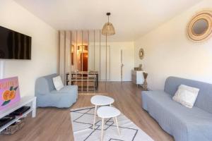 sala de estar con sofá azul y mesa en Grand studio pro calme proche centre commodités en Talence