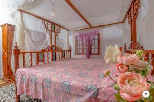 a bedroom with a canopy bed with a pink blanket at Suite Two Rooms - Watamu in Watamu