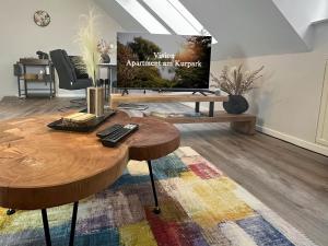 a living room with a tv and a wooden table at Vision - Apartment 43 - Bad Klosterlausnitz in Bad Klosterlausnitz