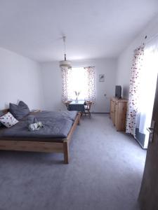 a bedroom with a bed and a table and a window at Pension Bernhard in Landl