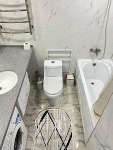 een badkamer met een toilet, een wastafel en een bad bij ITB Apartments Молодёжный in Alma-Ata