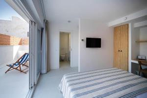 - une chambre avec un lit et une télévision murale dans l'établissement HOTEL BINI, à Porto Cristo