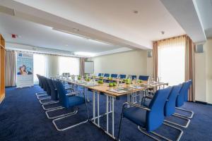 una sala de conferencias con una mesa larga y sillas azules en Best Western Hotel Halle-Merseburg, en Merseburgo