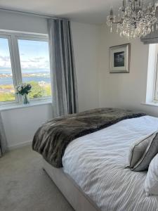 a bedroom with a large bed with a large window at Cardiff luxury apartments in Cardiff
