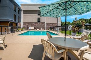 a table with an umbrella next to a swimming pool at Hampton Inn Winter Haven in Winter Haven