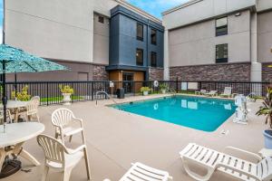 a swimming pool with chairs and a table and a patio at Hampton Inn Winter Haven in Winter Haven