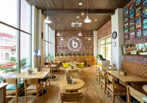 un restaurant avec des tables et des chaises et un mur en briques dans l'établissement Bloom Hotel - Jammu, à Jammu