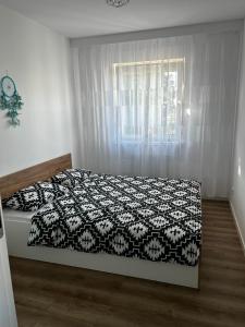 um quarto com uma cama com um edredão preto e branco em Apartament Anna em Leszno