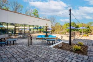 un patio con una fuente, mesas y sillas en DoubleTree by Hilton South Charlotte Tyvola en Charlotte