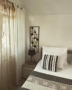 a bedroom with a bed with a black and white pillow at Apartment Panorama Mostar in Mostar