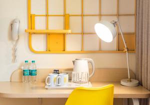 a table with a lamp and a coffee maker on it at Bloom Hotel - Jammu in Jammu