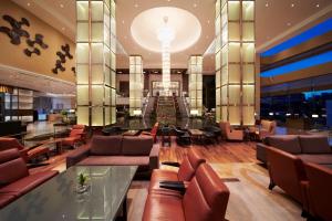a lobby with leather couches and a glass table at Hilton Kuala Lumpur in Kuala Lumpur