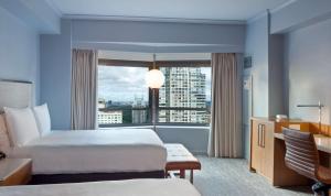 a hotel room with two beds and a large window at New York Hilton Midtown in New York