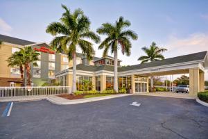 Hilton Garden Inn Sarasota-Bradenton Airport في ساراسوتا: فندق فيه نخل في مواقف السيارات