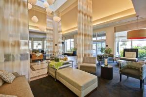 Hilton Garden Inn Sarasota-Bradenton Airport في ساراسوتا: غرفة معيشة كبيرة مع أريكة وكراسي