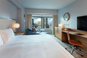 Pokój hotelowy z dużym łóżkiem i biurkiem w obiekcie New York Hilton Midtown w Nowym Jorku