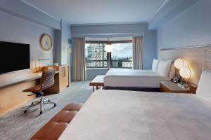 a hotel room with two beds and a flat screen tv at New York Hilton Midtown in New York +37 photos