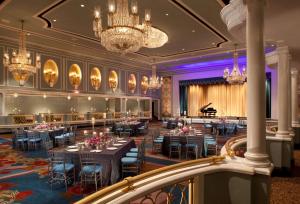 una sala banchetti con tavoli e pianoforte a coda di New York Hilton Midtown a New York