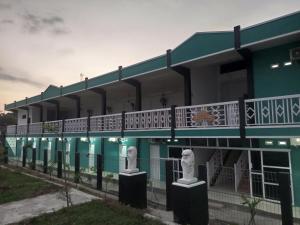 a building with two statues in front of it at Penginapan Lamban Queens Kamar Double Bed Standar Room in Kalianda