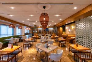 a restaurant with tables and chairs in a room at The First Collection Dubai Marina in Dubai