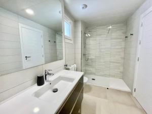 uma casa de banho branca com um lavatório e um chuveiro em Residencial Camaleones by AC REAL em Isla Canela