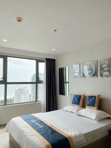 a bedroom with a large bed with a large window at Leo House - The Song Building 28 Thi Sách in Vung Tau