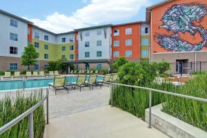 a building with a pool and chairs in front of it at Homewood Suites TechRidge Parmer @ I-35 in Austin