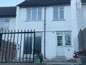 a white house with a gate in front of it at 4 Bed: 5mins frm Wembley Stadium in London