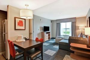a living room with a table and a room with a couch at Homewood Suites TechRidge Parmer @ I-35 in Austin