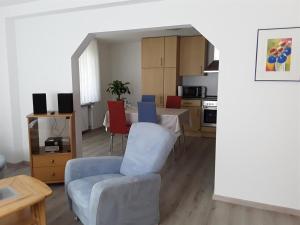 uma sala de estar com mesa e cadeiras e uma cozinha em Ferienwohnung Haus Emmerich em Saarburg