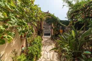 uma entrada para um jardim com um portão e plantas em Villa Marie Carmen em Rivesaltes