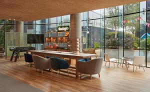 a dining room with a table and chairs and a piano at Aparthotel Adagio London Brentford in Brentford